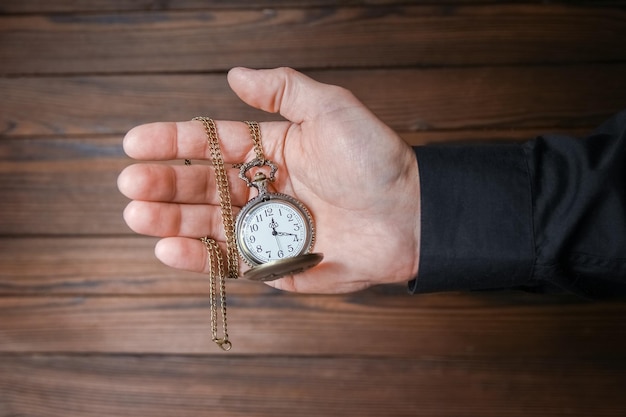 eine Taschenuhr in den Händen eines Mannes