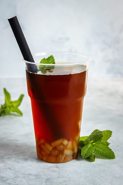 Eine Tasse Bubble Tea mit Minze auf grauem Hintergrund