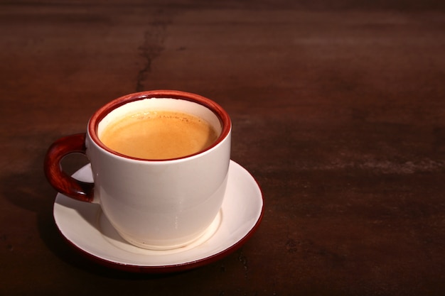 Eine Tasse Espressokaffee auf einer dunklen Holzoberfläche