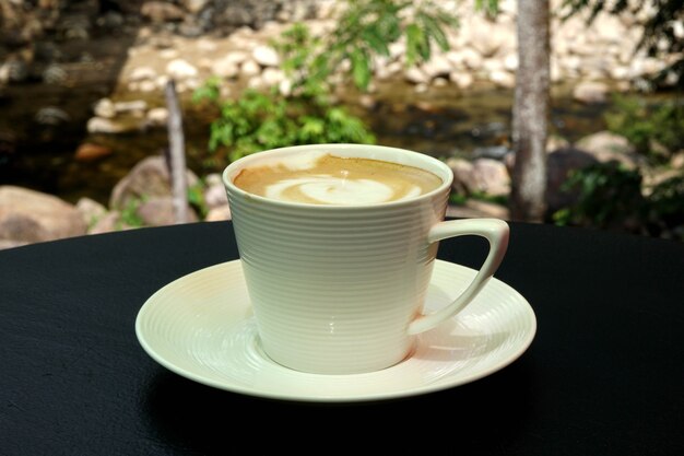 Eine Tasse heißen Latte-Art-Kaffee auf einem Holztisch