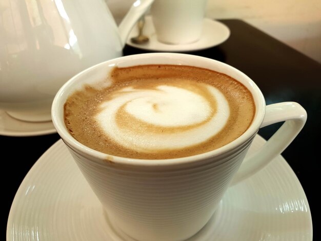 Eine Tasse heißen Latte-Art-Kaffee auf einem Holztisch