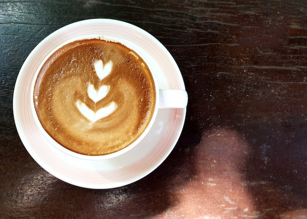 Eine Tasse heißen Latte-Art-Kaffee auf Holztisch