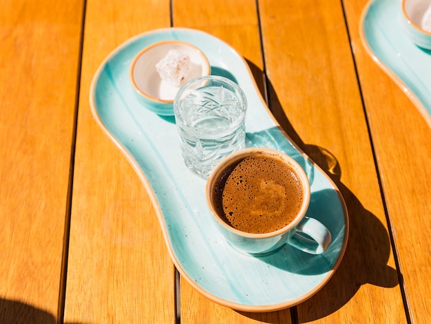 Eine Tasse heißen schwarzen türkischen Kaffee in blauer Tasse, serviert mit einem Glas Wasser und Zucker