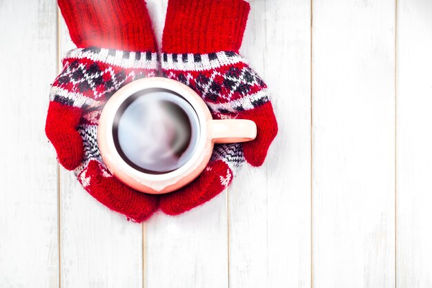 Eine Tasse heißes Getränk in den Händen