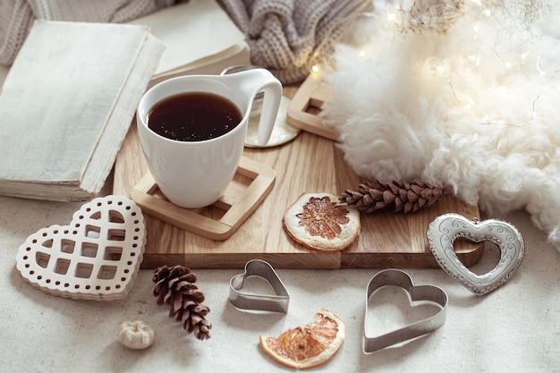 Eine Tasse heißes Getränk und süße Wohnaccessoires. Das Konzept von Wohnkomfort und Ästhetik.