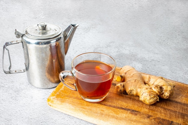 Eine Tasse Ingwerwasser auf Holz mit einer Teekanne Konzept Kräutermedizin Thailand