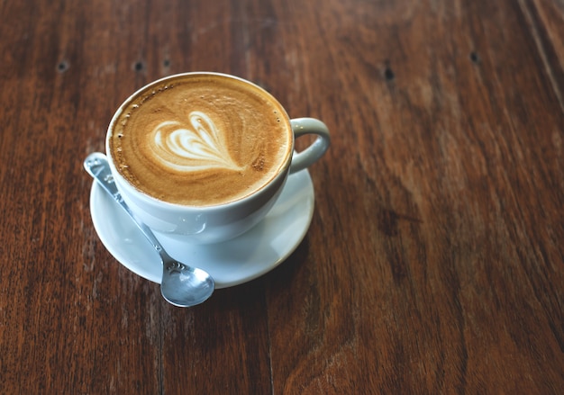 Eine Tasse Kaffee auf altem Holztisch.