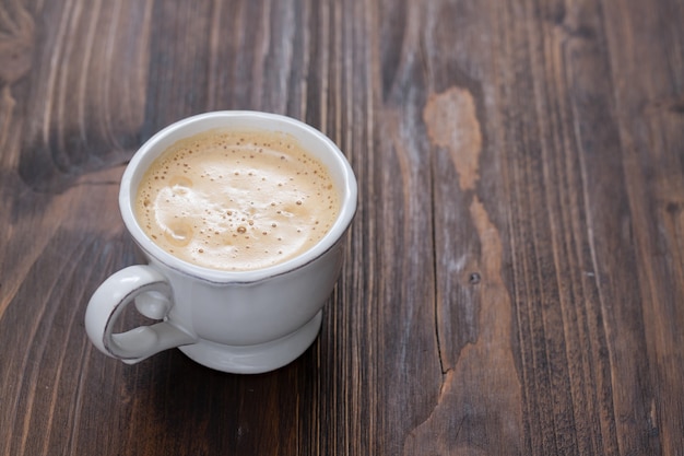 Eine Tasse Kaffee auf alter Holzoberfläche