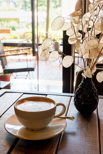 Foto eine tasse kaffee auf einem holztisch in einem café?