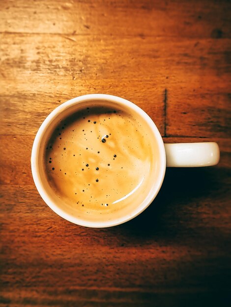 Eine Tasse Kaffee auf Holztisch.