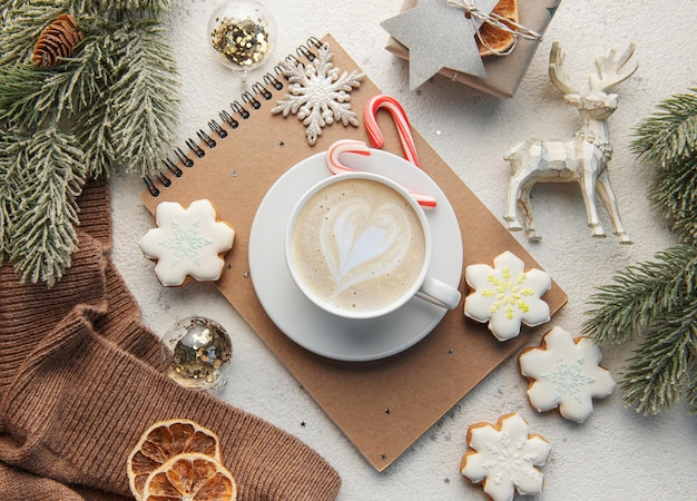 Eine Tasse Kaffee Latte hausgemachte Kekse und Weihnachtskugeln und Strickpullover