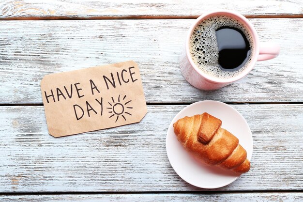 Foto eine tasse kaffee mit frischem croissant und eine gute massage am holztisch