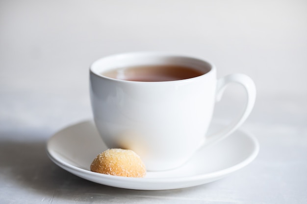 Eine Tasse Kaffee mit Keks auf Keramik