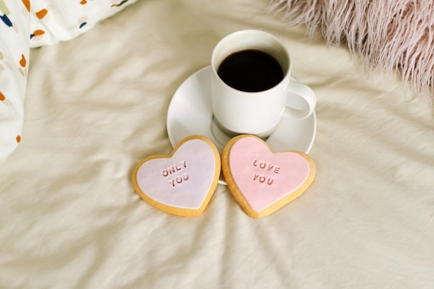 Eine Tasse Kaffee mit leckeren Keksen mit der Aufschrift love you Feiern Sie den Valentinstag zu Hause Konzept des Valentinstags