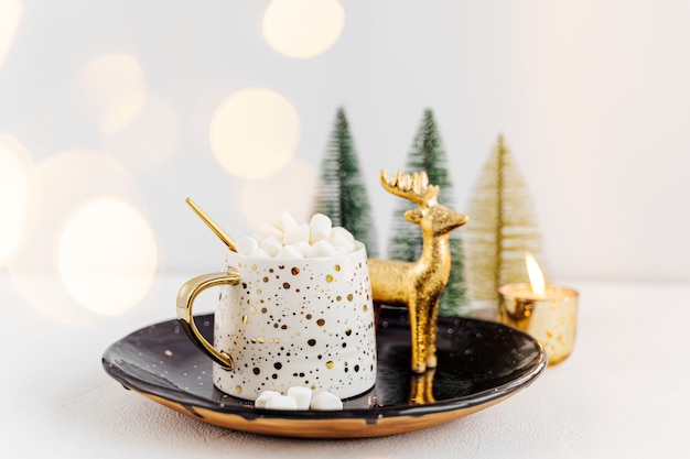 Eine Tasse Kaffee mit Marshmallow und Weihnachtsschmuck auf weißem Hintergrund. Urlaubskonzept.