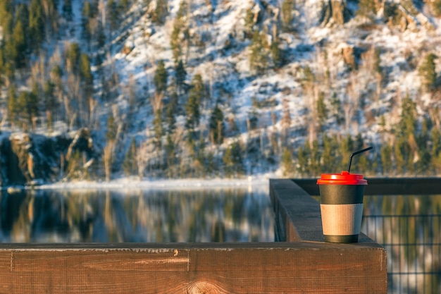 Eine Tasse Kaffee oder Tee auf dem Geländer an der Winterpromenade mit schöner Aussicht