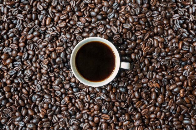 Eine Tasse Kaffee über gerösteten Kaffeebohnen