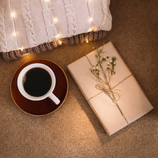 eine Tasse Kaffee und ein Buch über ein kariertes Lese- und Entspannungskonzept