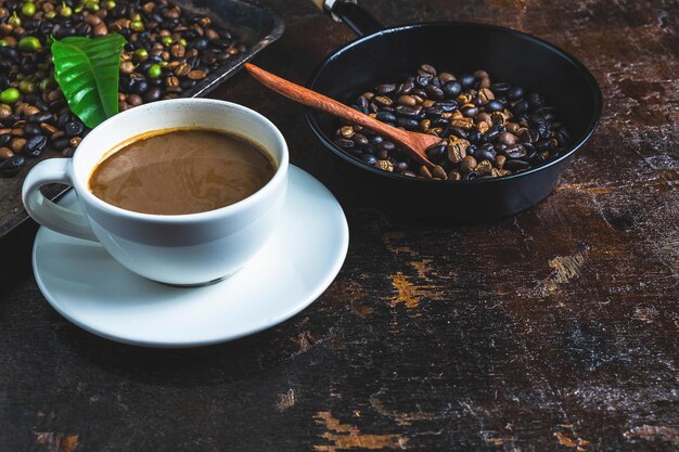 Eine Tasse Kaffee und Kaffeebohnen auf einem Holztisch