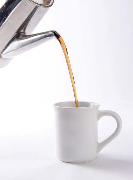 Eine Tasse Kaffee wird in einen weißen Becher gegossen.