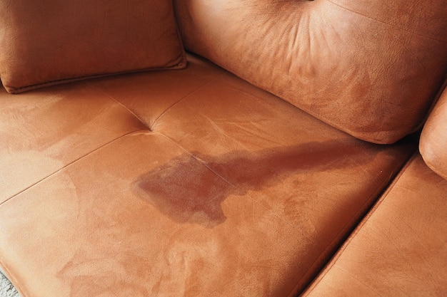 Eine Tasse Kaffee wurde auf dem grauen Sofa verschüttet