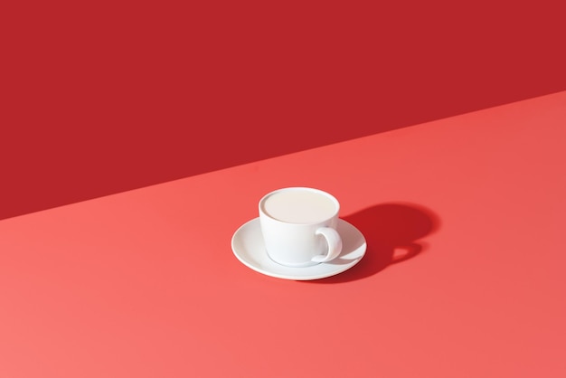 Eine Tasse Milch minimalistisch auf einem rosa Tisch