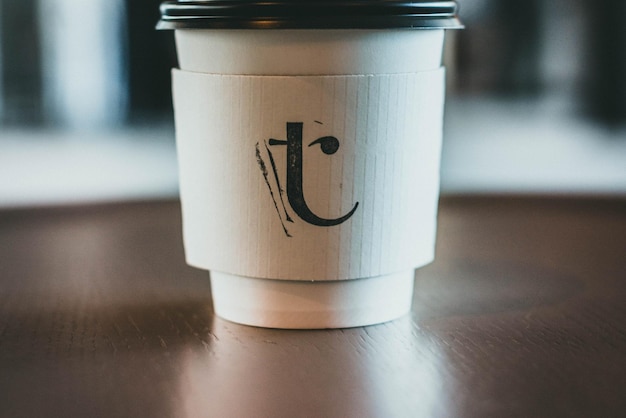 eine Tasse mit dem Buchstaben t sitzt auf einem Tisch