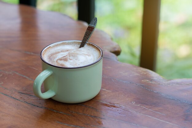 Eine Tasse Piccolo Latte auf einem hölzernen Schreibtisch, entspannende Zeit oder Kaffeepause am Arbeitstag