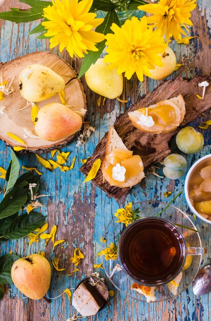 Eine Tasse schwarzen Tee und Marmelade aus Birnen auf ein Stück Brot, Ansicht von oben