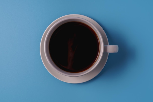 Eine Tasse schwarzer Kaffee auf Draufsicht des blauen Hintergrundes