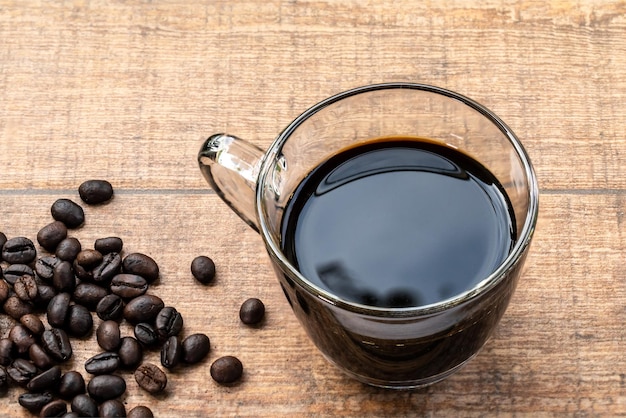 Eine Tasse schwarzer Kaffee auf Holzhintergrund