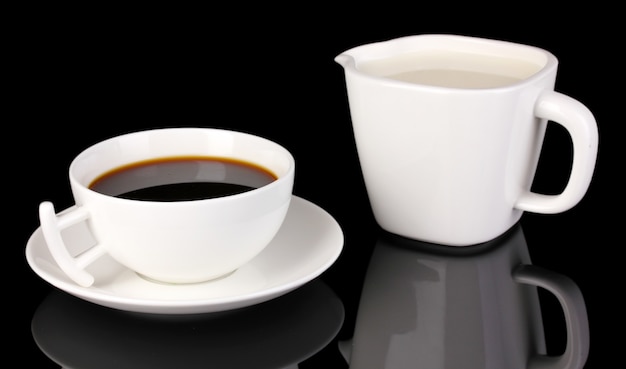 Eine Tasse starken Kaffee und süße Sahne isoliert auf Schwarz