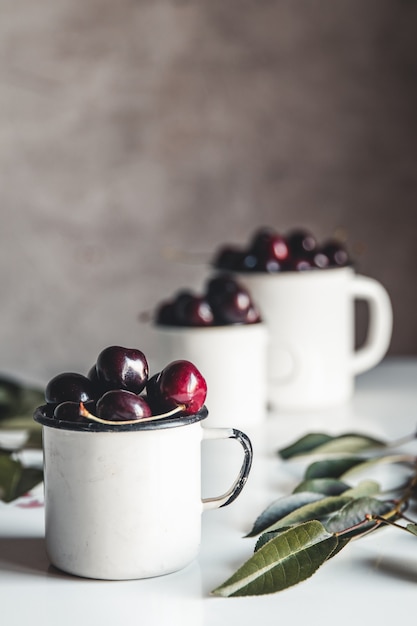 Eine Tasse Süßkirschen auf einem konkreten Hintergrund. Bio-Ökoprodukt, Bauernhof. Keine GVO