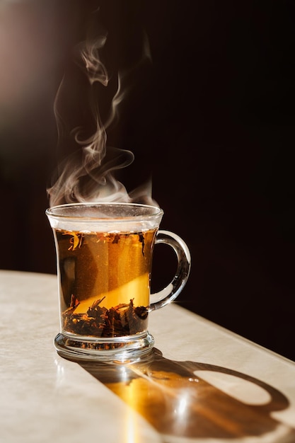 Eine Tasse Tee auf dem Küchentisch Schöner Dampf bei einem Drink Natürliches Licht aus dem Fenster