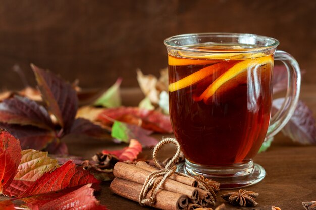 Eine Tasse Tee steht auf einem mit Herbstlaub übersäten Tisch