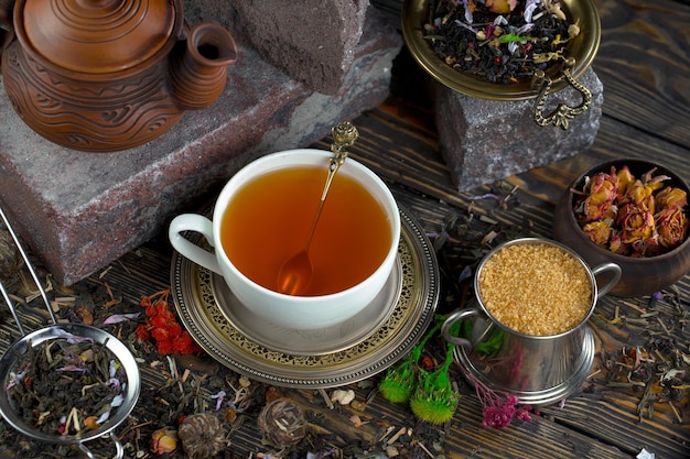 Eine Tasse Tee steht auf einem Tisch neben einer Teekanne mit Teekanne und einer Teekanne mit Teeblättern.