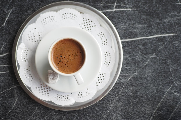 Eine Tasse türkischer Kaffee auf schwarzem Fliesen-Hintergrund