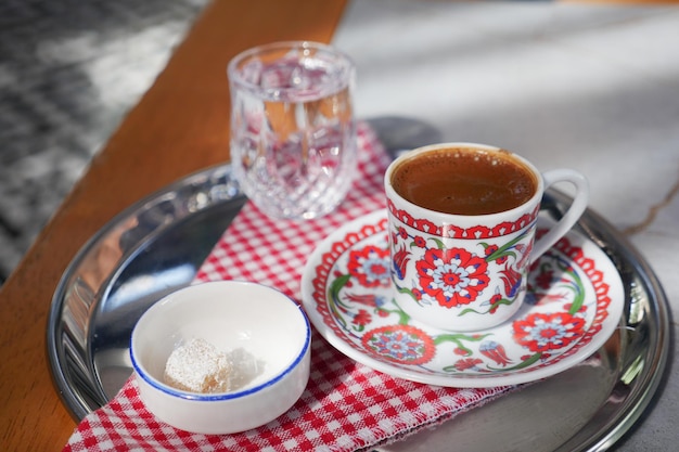 Foto eine tasse türkischer kaffee mit wasser und türkischen köstlichkeiten auf dem tisch