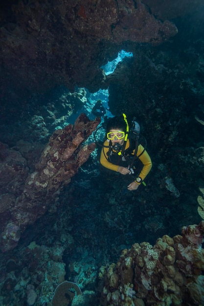 Eine Taucherin erkundet eine Unterwasserhöhle im Roten Meer.