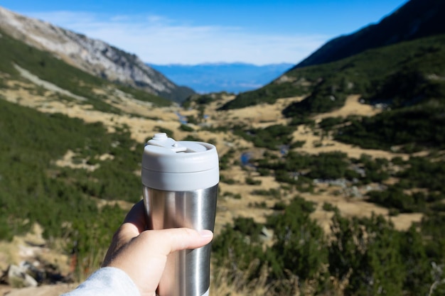 Eine Thermoflasche mit Getränk in den Bergen