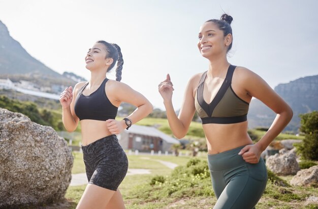 Eine tolle Freundschaft, die über die Distanz geht. Aufnahme von zwei fitten jungen Frauen, die in einem Park joggen gehen.