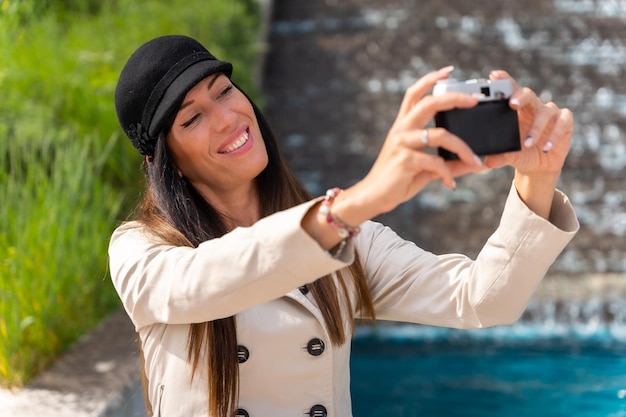 Eine Touristenfrau, die in ihrem Sommerurlaub in der Stadt ein Selfie mit der Fotokamera macht