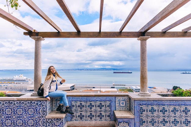 Eine Touristin sitzt mit geschlossenen Augen auf einer Panoramaplatform und genießt den dunklen Tag