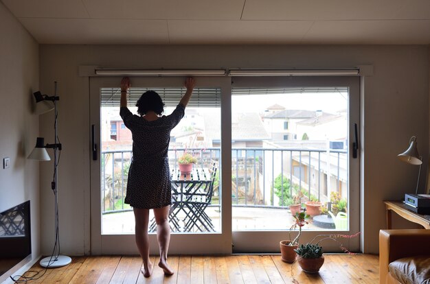 Eine traurige Frau, die zu Hause aus dem Fenster schaut