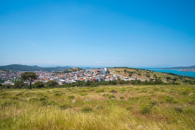 Eine türkische Kleinstadt mit Blick auf das Meer und eine grüne Wiese an einem sonnigen Sommertag