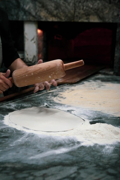 Eine türkische Pizza oder Lahmacun Fast Food und beliebtes Street Food in Mittelmeerländern zubereiten D