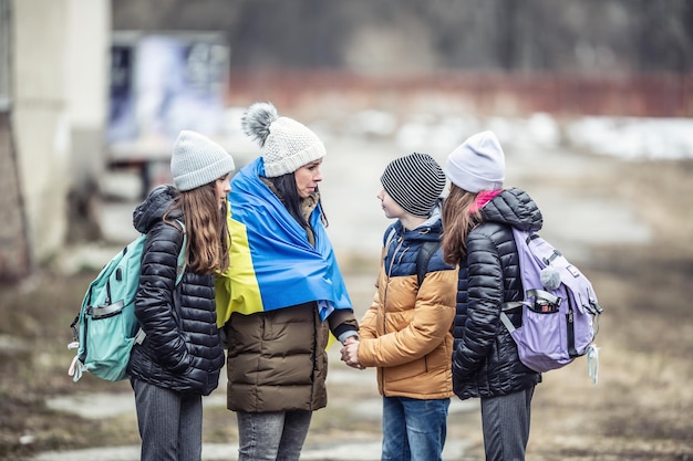 Eine ukrainische Frau, die mit Kindern vor dem Konflikt flieht, versichert ihren drei Kindern, dass alles gut wird