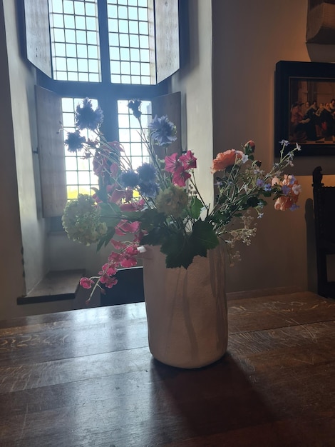 Foto eine vase mit blumen und ein bild eines fensters