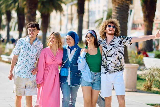 Foto eine vielfältige gruppe von touristen, die in sommerkleidung gekleidet sind, spazieren durch die touristenstadt mit breiten