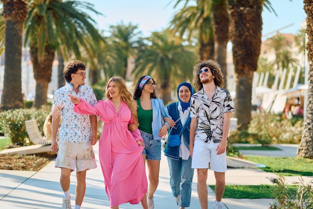 Eine vielfältige Gruppe von Touristen, die in Sommerkleidung gekleidet sind, spazieren durch die Touristenstadt mit breiten